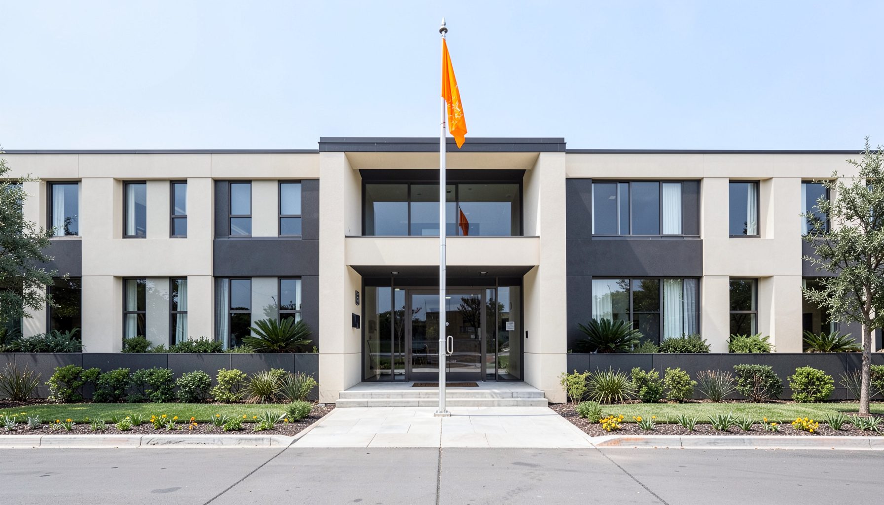 A symmetrical front office building entrance with a flag pole and clean landscaping, charcoal and off-white tones, professional mood